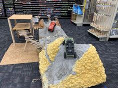 a toy car is sitting on top of a pile of sand in a store aisle