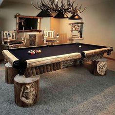 a pool table made out of logs and some lights