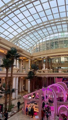 the inside of a shopping mall with people walking around