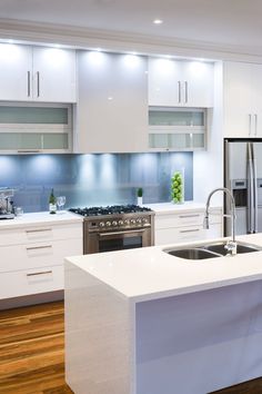 a modern kitchen with white cabinets and stainless steel appliance in the center island