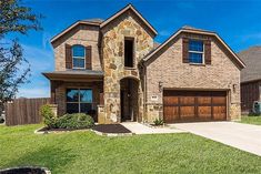 a brick and stone house with two garages