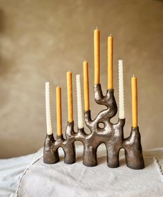 five candles are arranged in the shape of elephants on a white cloth with a brown background