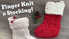 two knitted christmas stockings sitting on top of a wooden floor next to a pine cone