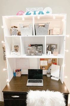 a laptop computer sitting on top of a wooden desk in front of a book shelf