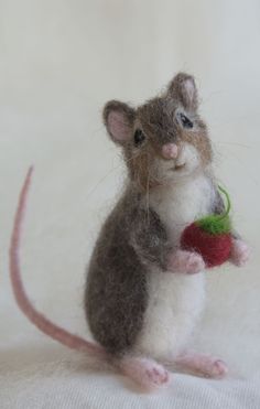 a needled mouse holding a red apple