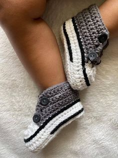 a close up of a child's feet wearing crocheted slippers with buttons