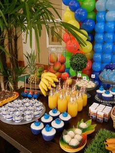 a table filled with lots of food and balloons