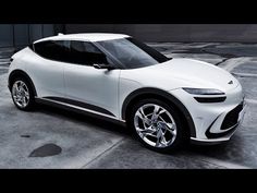 a white electric car parked in a parking lot next to an empty area with no people