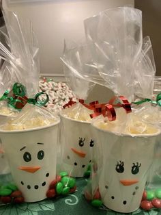 two cups filled with marshmallows and snowman faces