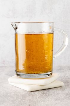 a glass mug filled with liquid sitting on top of a napkin