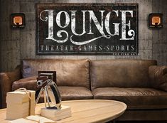 a couch and table in a room with a sign above it that says lounge theater games sports