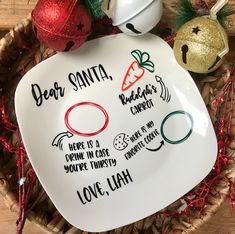 a plate with some writing on it and two ornaments in the basket next to it