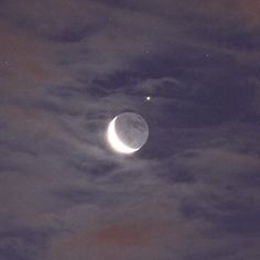 the moon and venus are visible in the night sky above some clouds on a cloudy day