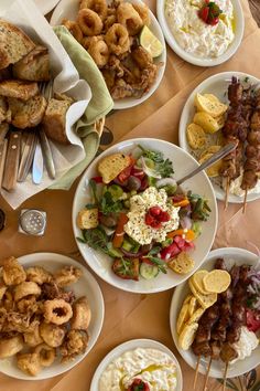 a table topped with plates filled with different types of food and utensils on top of each plate