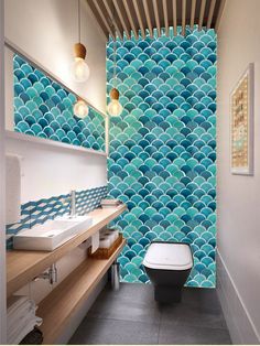 a bathroom with blue and white tiles on the walls, along with a toilet and sink