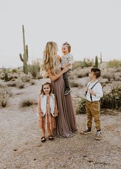 a woman and two children standing in the desert