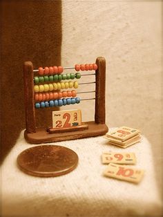 a wooden abacusk sitting on top of a table next to two penny coins