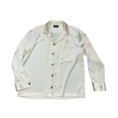 The ALYA shirt, eloquently designed by YOUSEFI, is a testament to urban luxury apparel. Made from top quality silk, this off-white ensemble exudes a sense of sophisticated elegance and refined style. The button-down shirt adoringly embellished with gold buttons and long sleeves.      The quality is unparalleled, with meticulous attention given to every detail, ensuring that each piece drapes beautifully and feels soft against the skin. The neutral off-white hue lends itself perfectly to be paired with gold or silver accessories for a glamorous evening look or subdued with earth-tones for a more relaxed, daytime aesthetic. Daytime Aesthetic, Jackets Streetwear, Hoodies Streetwear, Streetwear Jackets, Pants Streetwear, Streetwear Shirts, Streetwear Pants, Silver Accessories, Urban Outfits