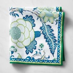 a blue and green floral napkin on a white surface