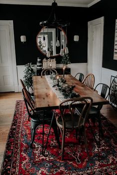 the dining room table is set with christmas decorations and greenery on top of it