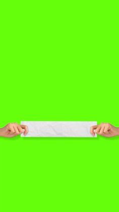 two hands holding a white paper against a green background