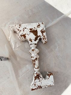 an old rusted metal object sitting on top of a plastic bag next to a toilet