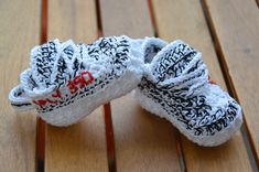 two pieces of fabric sitting on top of a wooden table covered in black and white writing