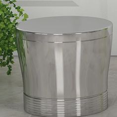 a round metal table sitting next to a potted plant