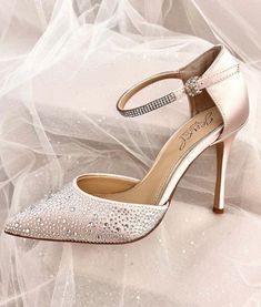 a pair of women's wedding shoes sitting on top of a white cloth covered floor