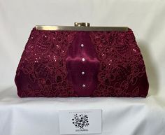 Your wedding or special occasion outfit will be complete, with this burgundy wine satin shantung embroidered sequin corded lace clutch purse evening bag.   Front and back are covered with lace.  Four crystals are delicately placed on each side.  Optional chain strap is available in lengths of 15.5" or 47.5". Height is 5", length at top is 7" and length at bottom is 10.5".  It expands to 2" at bottom.  The clutch has body and stands by itself.  Please keep in mind this bag is not designed for car Elegant Burgundy Evening Bag, Elegant Burgundy Clutch Bag, Luxury Burgundy Clutch For Evening, Burgundy Clutch Bag, Wine Evening, Luxury Burgundy Bags With Silver-tone Hardware, Lace Clutch, Occasion Outfit, Clutch Purse Evening