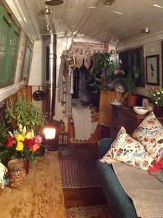 a living room filled with lots of furniture and flowers on top of a wooden table