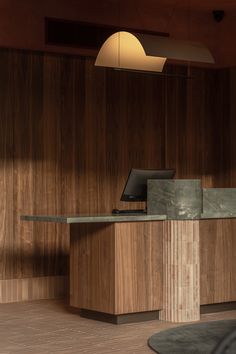 a desk with a laptop on it in front of a wooden paneled wall and floor