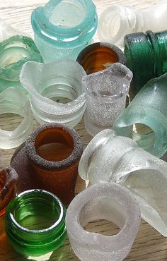 there are many different colored glass bottles on the table