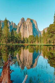 the mountains are reflected in the still water