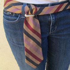 there is a woman wearing a striped tie on her waist and blue jeans with the belt undone