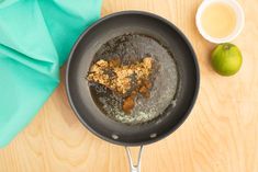 a frying pan filled with food next to an apple and a cup of tea