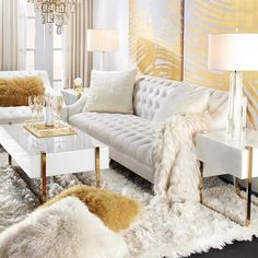 a living room filled with white furniture and lots of fur on the floor next to a chandelier