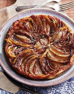 an onion dish on a plate with fork and knife