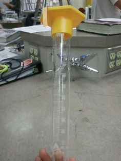 a yellow and clear measuring tube on top of a table