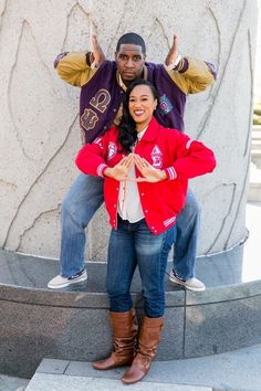 a man and woman posing for a photo in front of a statue with their arms around each other