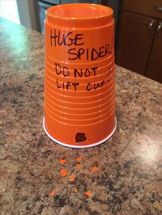 an orange trash can sitting on top of a counter next to some confetti