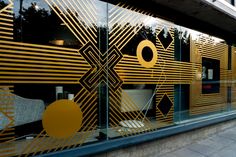 an artisticly designed glass window on the side of a building with gold and black designs