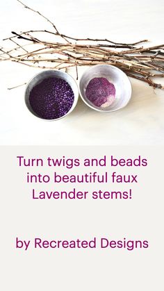 two white bowls filled with purple colored sand next to twig sticks on a table