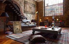 a living room filled with furniture next to a brick wall and stair case in the background