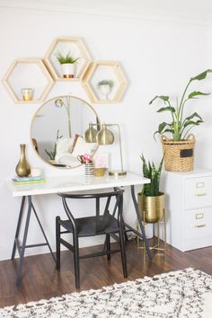 a white desk topped with a mirror next to plants and potted plants on top of it