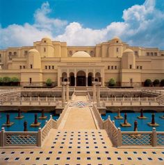 a large building that is next to a body of water with blue and white tiles on the ground