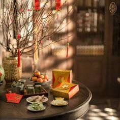 a table topped with plates and cups filled with food next to a vase full of flowers