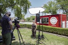 two people standing in front of a red food truck