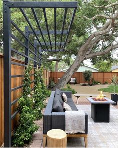 an outdoor living area with couches, tables and a fire pit in the middle