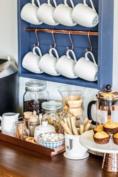 the coffee bar is stocked with cups, muffins and pastries for breakfast